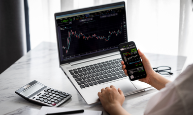 persona investe in etf usando smartphone e computer